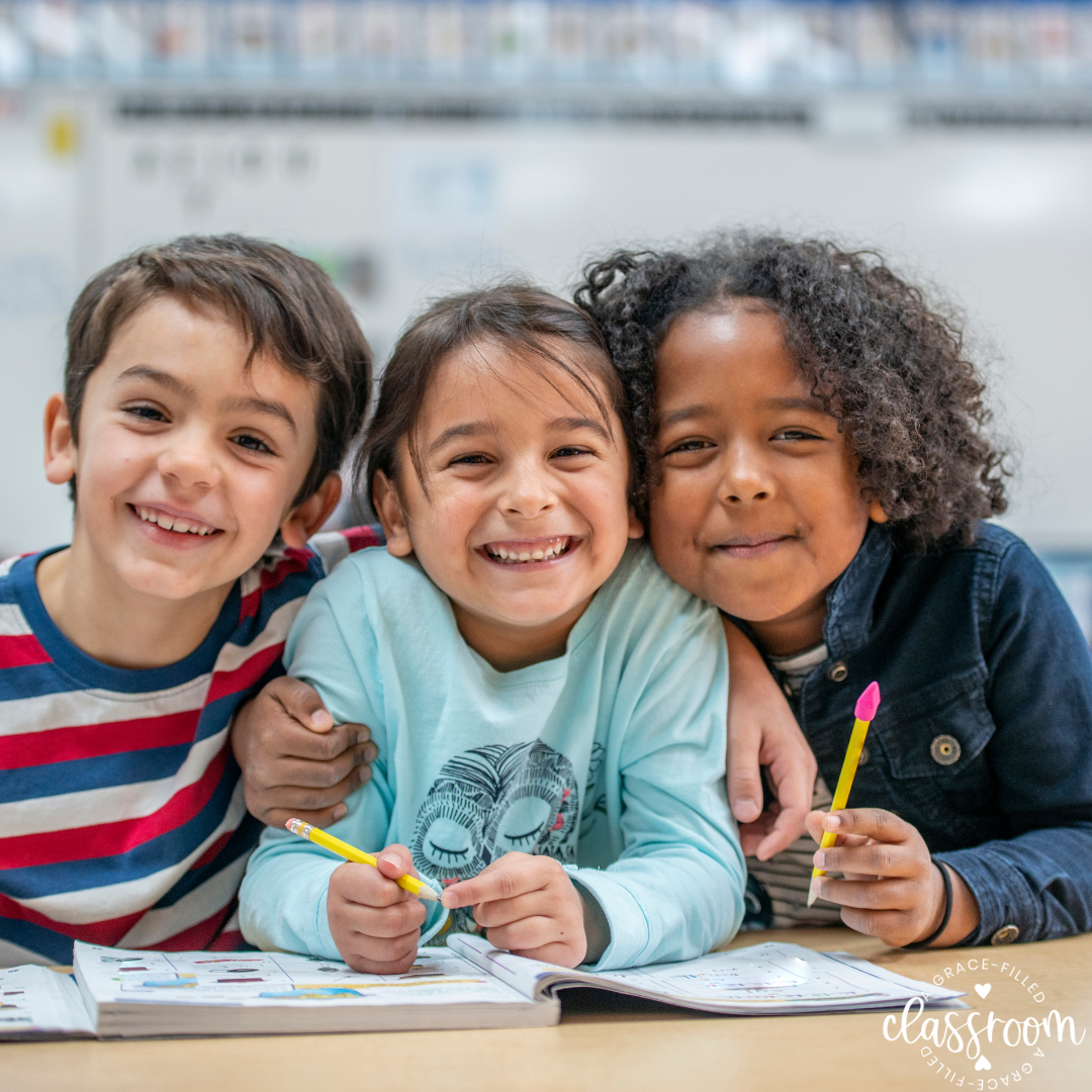 Three students in class smiling and doing classwork together